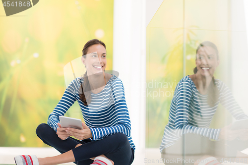 Image of young women using tablet computer on the floor