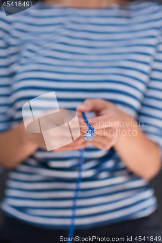 Image of woman holding a internet cable in front of chalk drawing board