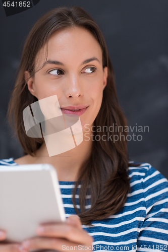 Image of woman using tablet  in front of chalk drawing board