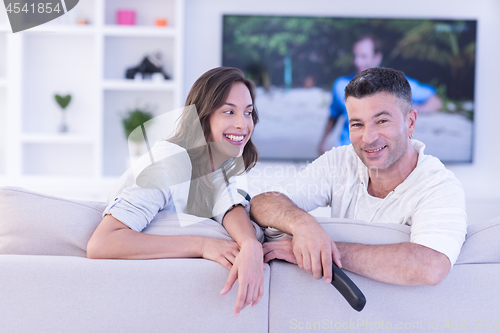 Image of Young couple on the sofa watching television