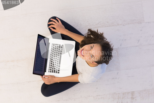 Image of women using laptop computer on the floor top view