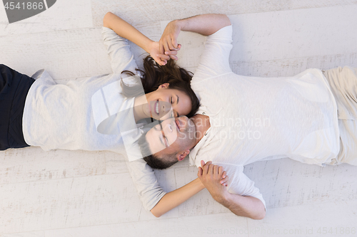 Image of handsome couple lying on floor