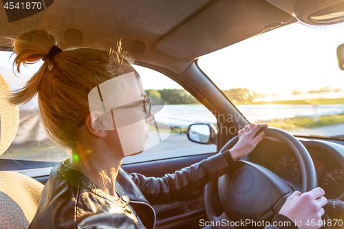 Image of Casual caucasian woman driving passenger car for a journey in countryside.