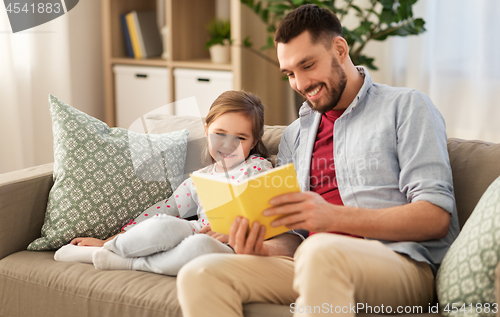 Image of happy father and daughter reading book at home