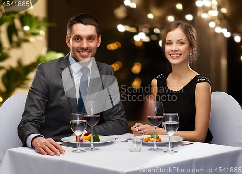 Image of couple with food and red wine at restaurant