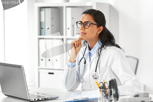 Image of female doctor with laptop and papers at hospital