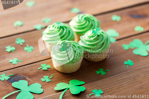 Image of green cupcakes and shamrock on wooden table