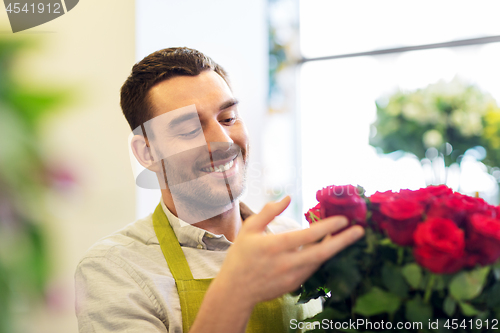 Image of florist or seller setting red roses at flower shop