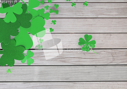 Image of green paper shamrocks on wooden background