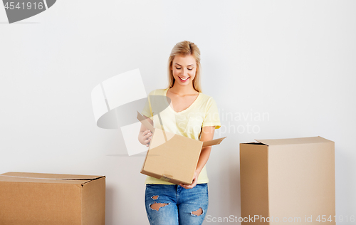 Image of happy woman with cardboard box moving to new home