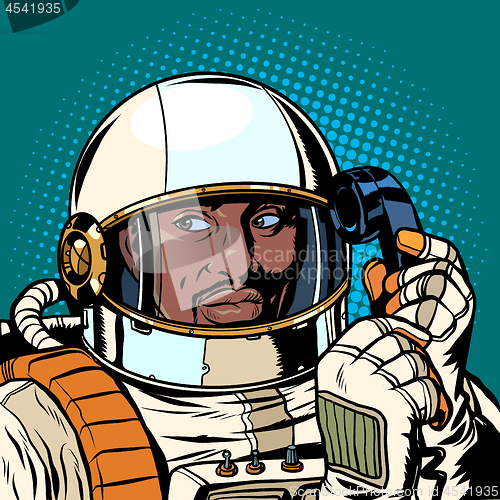 Image of serious african astronaut talking on a retro phone