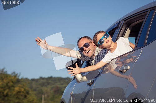 Image of Happy father and son sitting in the car at the day time.