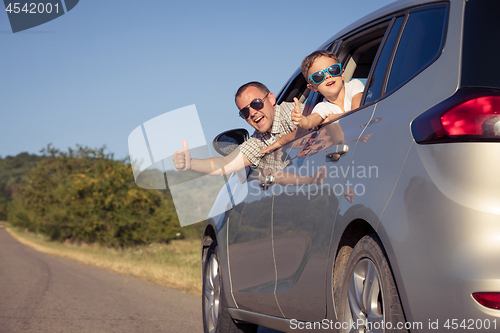 Image of Happy father and son sitting in the car at the day time.