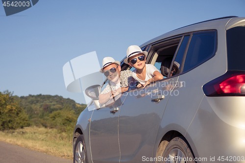 Image of Happy father and son sitting in the car at the day time.