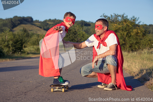 Image of Father and son playing superhero at the day time.