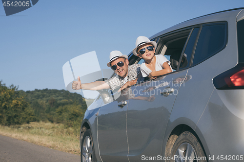 Image of Happy father and son sitting in the car at the day time.