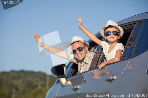 Image of Happy father and son sitting in the car at the day time.