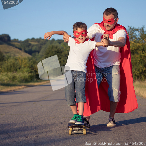 Image of Father and son playing superhero at the day time.