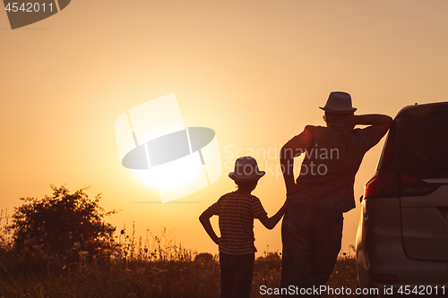 Image of Father and son playing in the park at the sunset time.