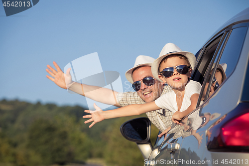 Image of Happy father and son sitting in the car at the day time.