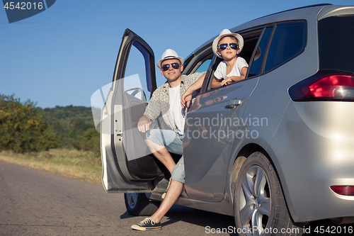 Image of Happy father and son sitting in the car at the day time.