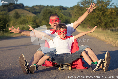 Image of Father and son playing superhero at the day time.