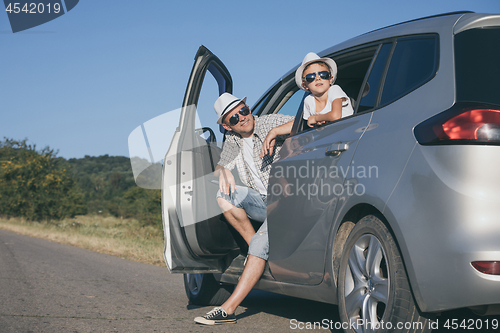 Image of Happy father and son sitting in the car at the day time.