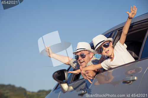 Image of Happy father and son sitting in the car at the day time.