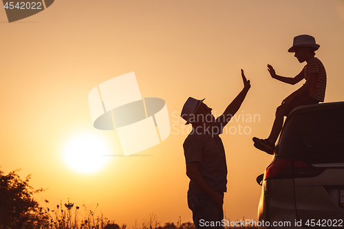 Image of Father and son playing in the park at the sunset time.