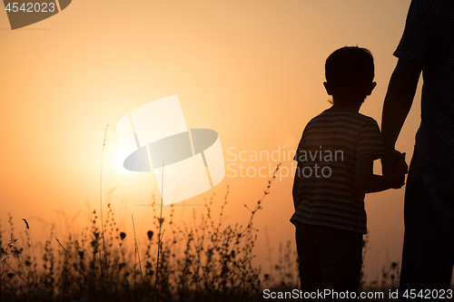 Image of Father and son playing in the park at the sunset time.