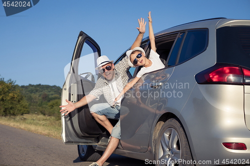 Image of Happy father and son sitting in the car at the day time.