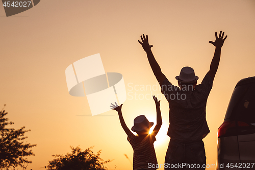 Image of Father and son playing in the park at the sunset time.