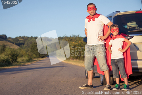 Image of Father and son playing superhero at the day time.