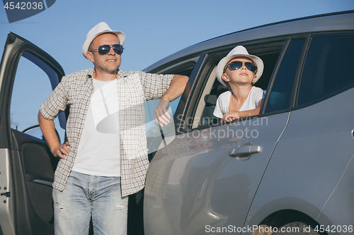 Image of Happy father and son sitting in the car at the day time.