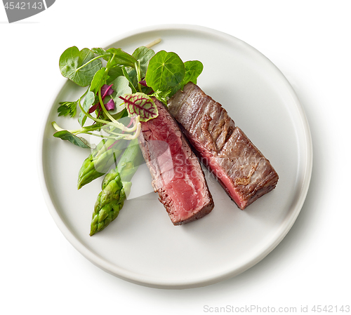 Image of Plate of beef wagyu steak meat with herbs and asparagus