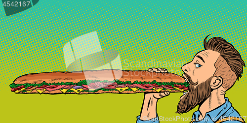 Image of man eats a long sandwich