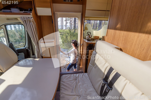 Image of Woman in the interior of a camper RV motorhome with a cup of cof