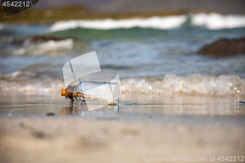 Image of Message in the bottle against the Sun setting down