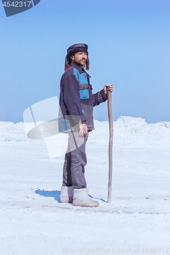 Image of Man In Ethnic Clothes Standing Among The White Mounds 