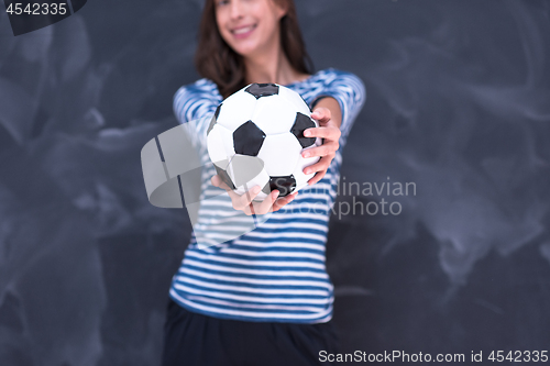 Image of woman holding a soccer ball in front of chalk drawing board