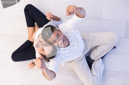 Image of couple sitting with back to each other on floor