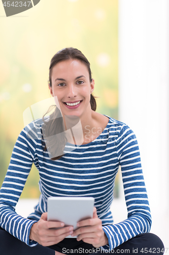 Image of young women using tablet computer on the floor