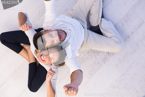 Image of couple sitting with back to each other on floor