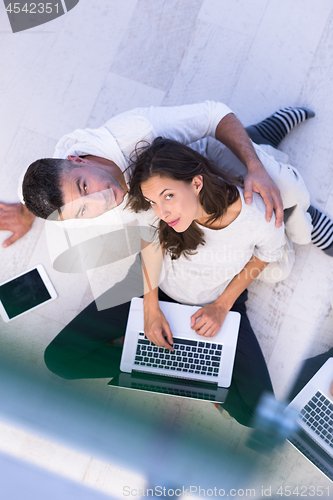 Image of couple using tablet and laptop computers top view