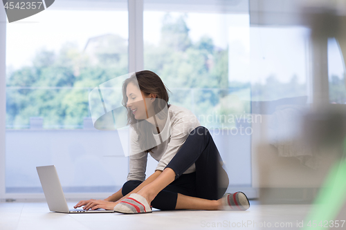 Image of young women using laptop computer on the floor
