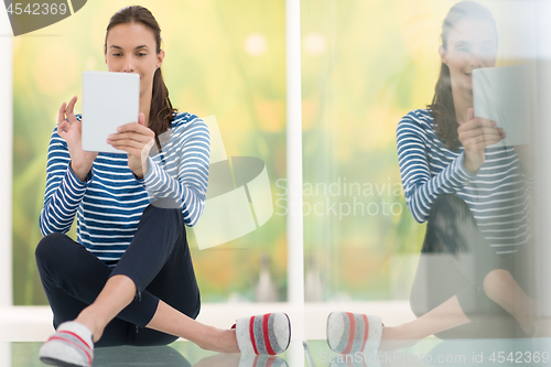 Image of young women using tablet computer on the floor