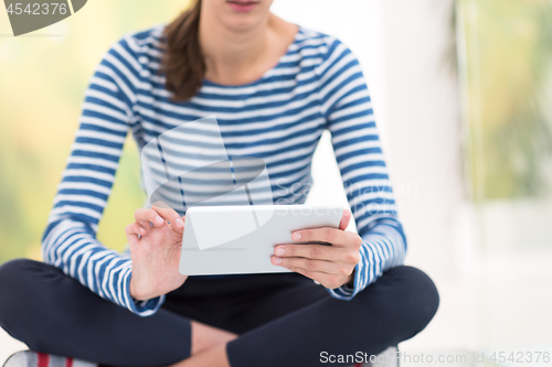 Image of young women using tablet computer on the floor