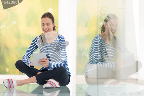 Image of young women using tablet computer on the floor