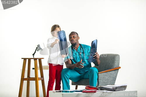 Image of Young african male pediatrician explaining X-ray to child