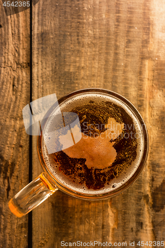 Image of Chinese beer concept, China silhouette on foam in beer glass on wooden table.